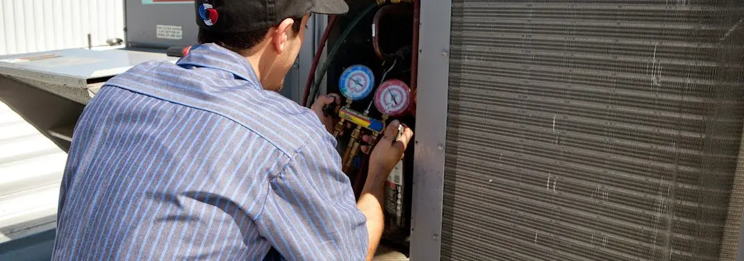 HVAC technician servicing a condenser unit in St. Helena