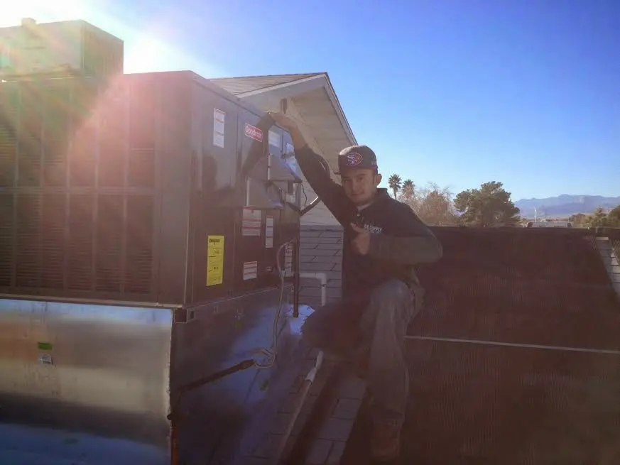 HVAC technician performing AC Tune-Up on a rooftop unit in St. Helena